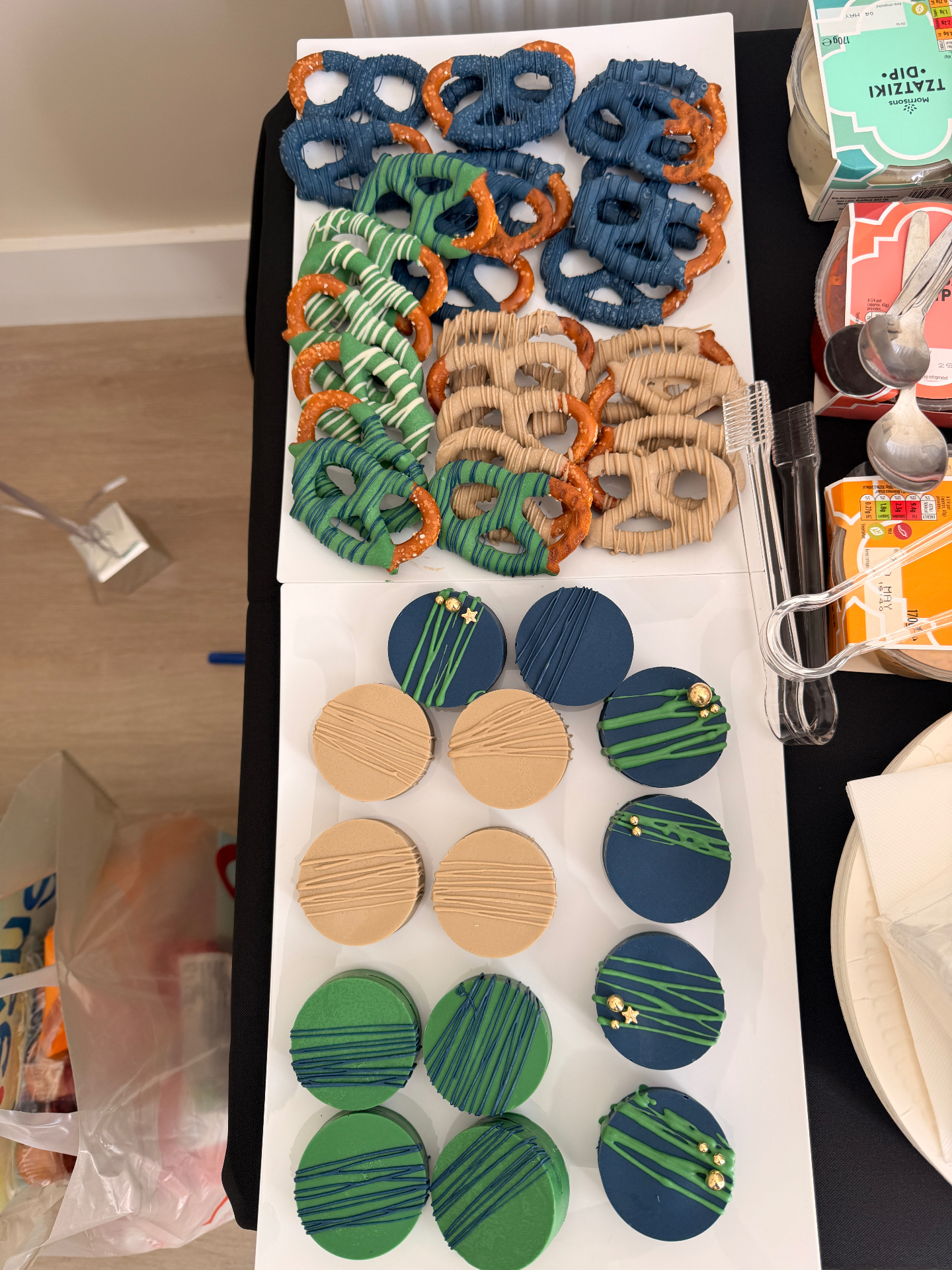 Hand-decorated chocolate-dipped pretzels and Oreos in navy, green and caramel